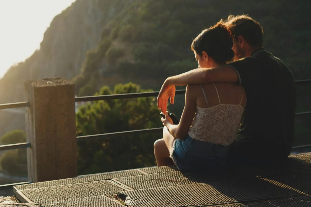 man and woman sitting on concrete surface